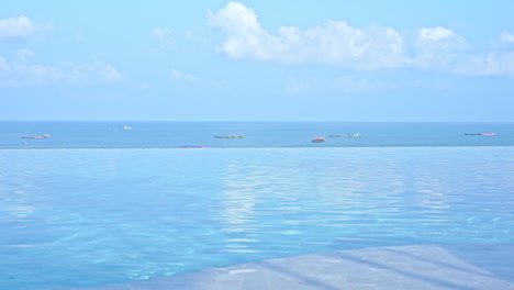 Oberflächenwasser-Aus-Infinity-Pool,-Boote-Im-Meereshintergrund