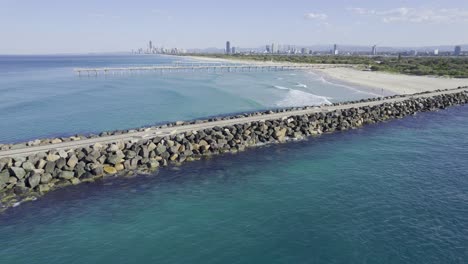 the spit seawall with sand bypass pumping jetty in the distance - main beach, australia