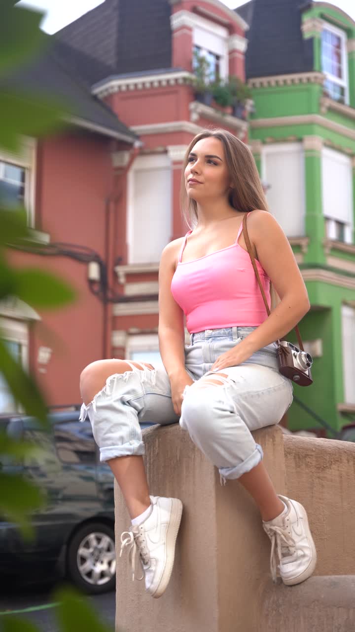 Woman sitting outdoors with a camera