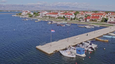 small boats anchored at concrete harbor of nin in croatia, aerial