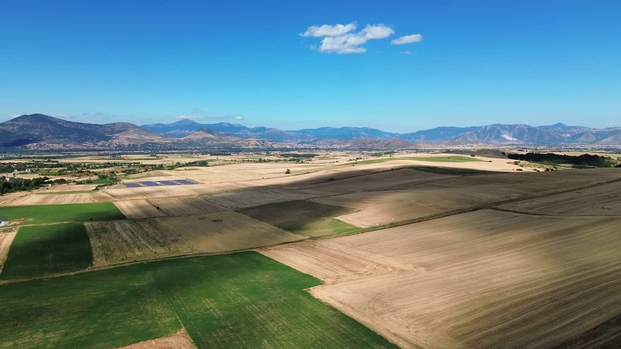 Greece countryside rural agriculture fields green yellow crop growing aerial drone mountains skyline