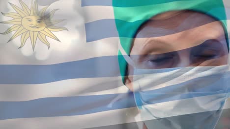 animación de agitar la bandera uruguaya contra una cirujana caucásica con máscara quirúrgica en un hospital