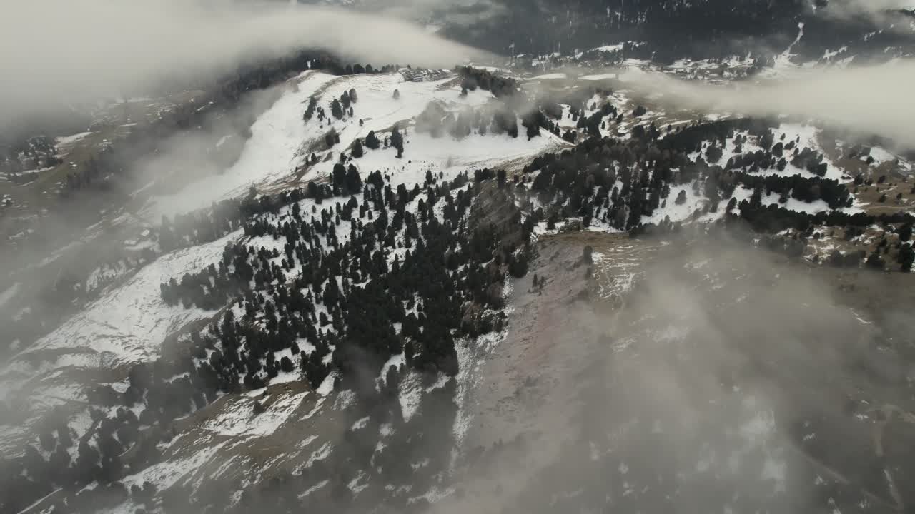 video aéreo de las montañas rocosas italianas parcialmente cubiertas de nieve y nubes en invierno