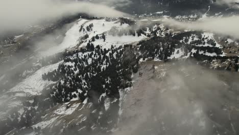 Aerial-video-of-rocky-Italian-mountains-partly-covered-with-snow-and-clouds-in-winter