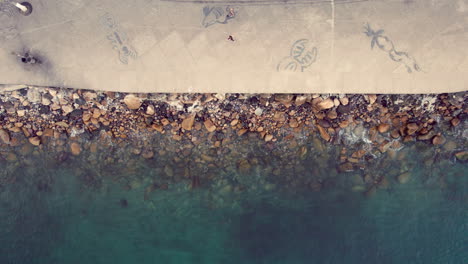 Serene-video-featuring-a-zenithal-view-of-the-Puerto-Vallarta-boardwalk,-capturing-the-waves-breaking-on-the-shoreline,-conveying-a-sense-of-peace-and-tranquility