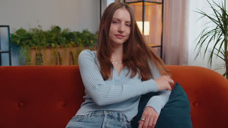 Close-up-portrait-of-happy-smiling-beautiful-young-woman-in-blue-blouse,-looking-at-camera-at-home