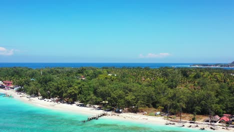 isla tropical con vegetación exuberante y bosque de palmeras junto al mar azul turquesa que lava la playa de arena blanca, ubicación perfecta para vacaciones en indonesia
