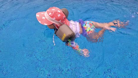 Niña-De-3-Años-Aprende-A-Nadar-En-Una-Piscina-En-Un-Día-Lluvioso