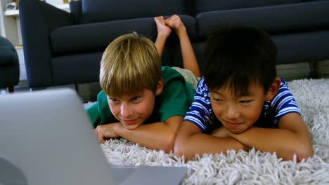 hermanos usando computadora portátil en la sala de estar