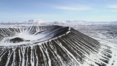 aerial-of-the-Hverfjall-volcano-in-Iceland-and-surrounding-mountains-covered-in-snow