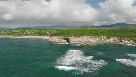 Breite-Luftaufnahme,-Die-Aus-Der-Ferne-Am-Shipwreck-Beach,-Hawaii,-Um-Die-Klippe-Kreist