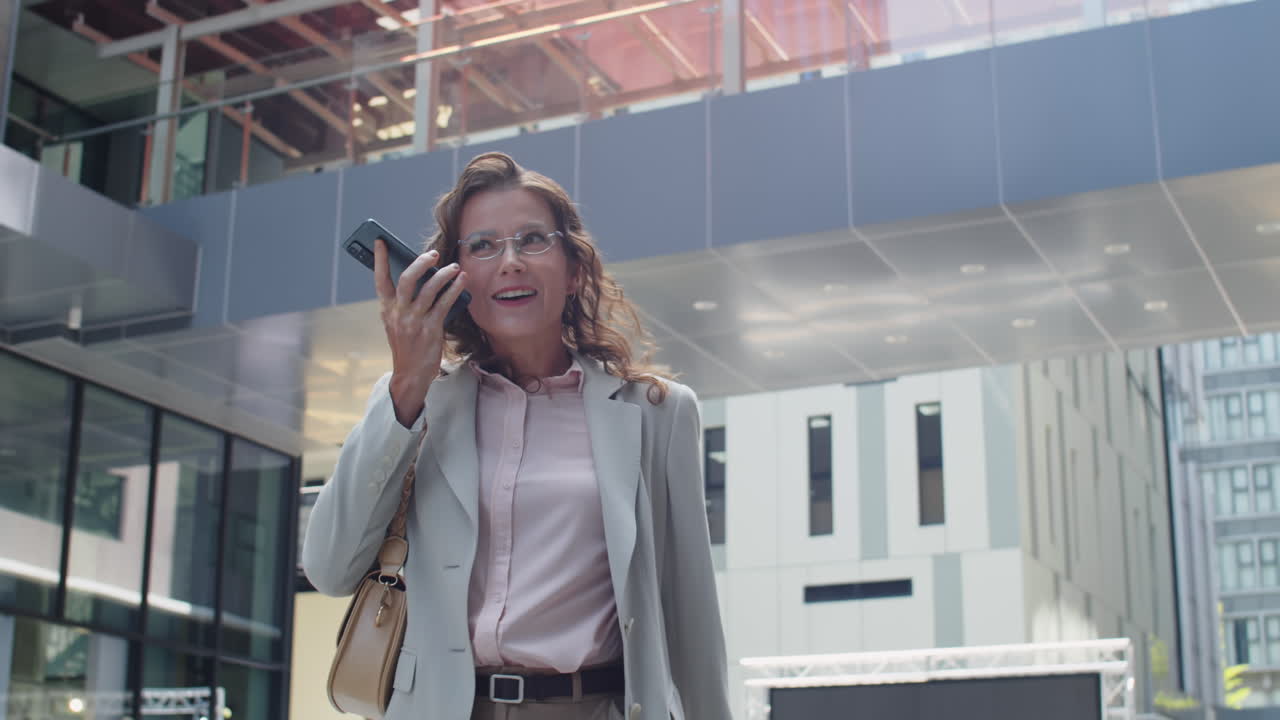 Woman in Formal Wear Sending Voice Message on Phone in Business District