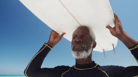 senior man with a surfboard at the beach