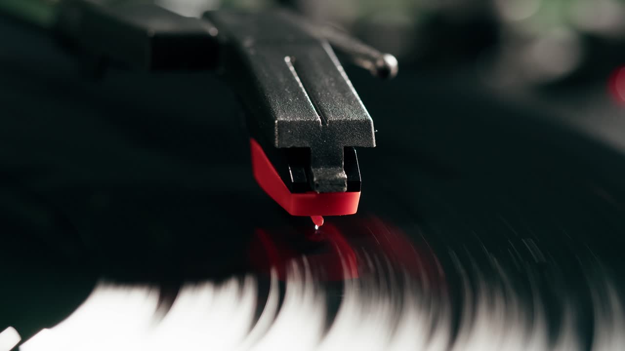 Primo piano della puntina di un giradischi che riproduce un disco in vinile nero