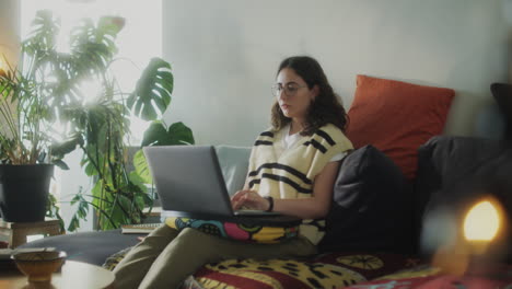 girl using laptop on sofa at home