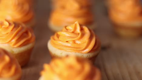 Close-up-focus-pull-of-little-cup-cakes-on-wooden-surface