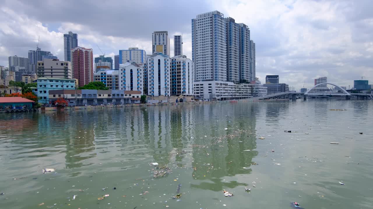 Seagulls scavenging over floating trash and debris on Pasig River in capital city of Manila Philippines