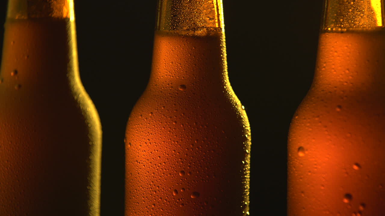 Three beer bottle rotating on black background