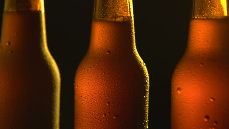 three beer bottle rotating on black background