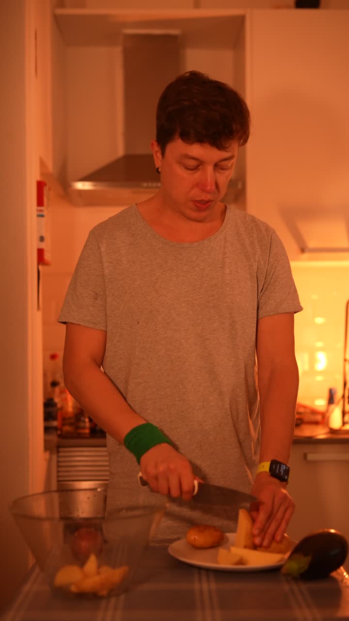 hombre preparando patatas y verduras en la cocina