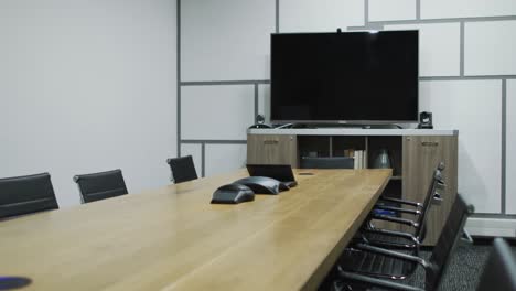 general view of empty conference room with television monitor, table and chairs in office