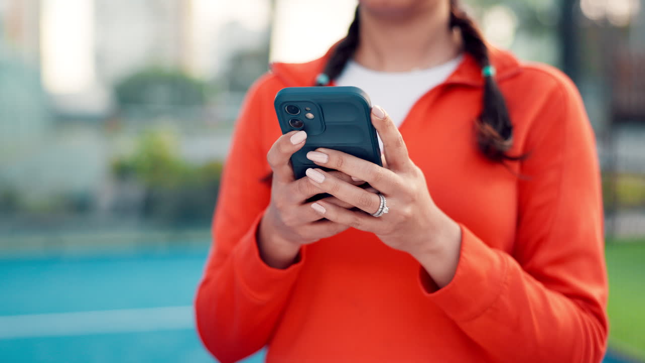 Woman's Hands Using a Smartphone Outdoors