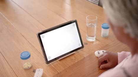 close up of senior biracial woman using tablet with copy space on screen, slow motion