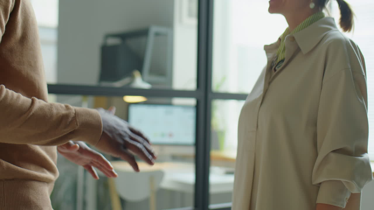 Coworkers Shaking Hands and Having Talk in Office