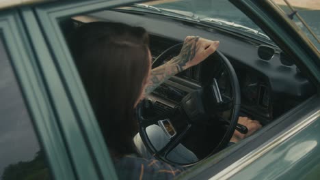 una mujer conduciendo un coche de época.