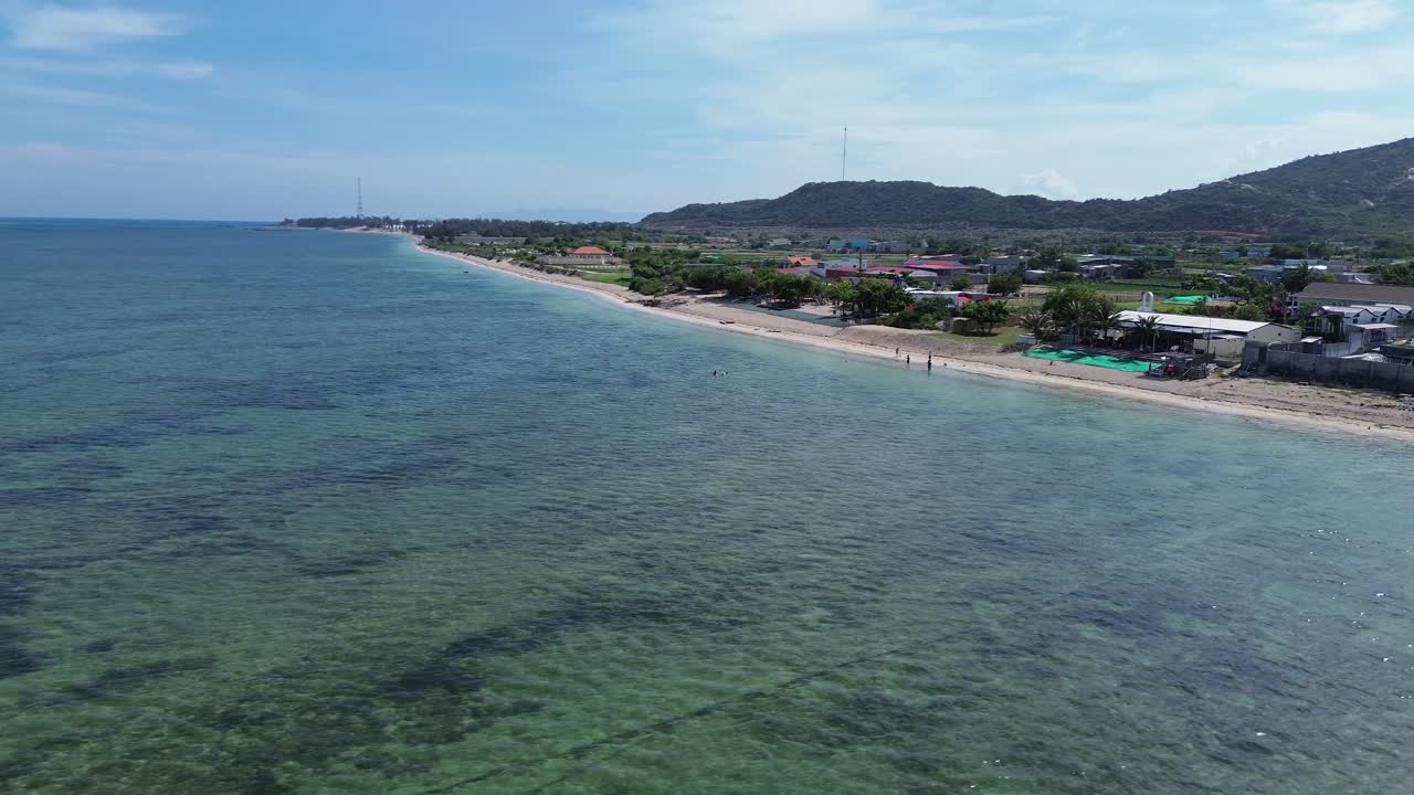Aerial view of My Hoa Lagoon in Phan Rang, Vietnam, recorded with a beautiful semi orbit drone shot around the shoreline and coastal landscape.