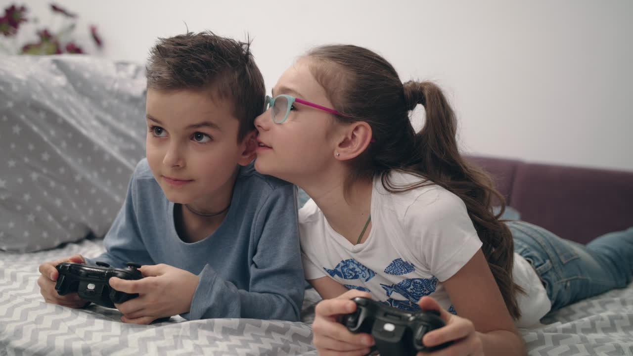 Bambini felici che giocano a un videogioco con il joystick a casa. Amici che giocano alla console.