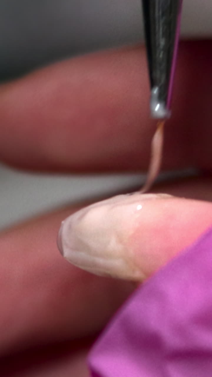 Close-up of Nail Technician Applying Gel to Fingernail