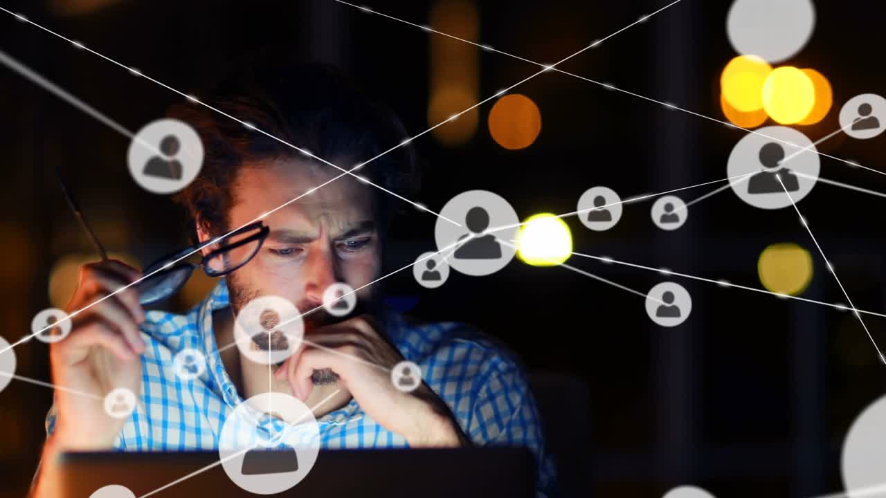 Man working late on laptop, tech network icons multiplying and overlaying screen, causing fatigue