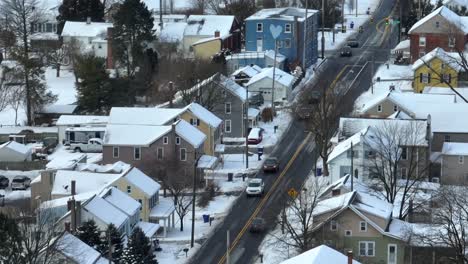 Langer-Luftzoom-Von-Autos,-Die-Auf-Der-Straße-Durch-Ein-Mit-Winterschnee-Bedecktes-US-Viertel-Fahren