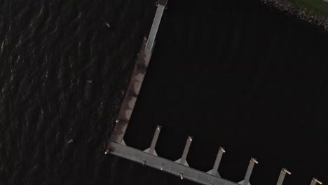 Bird's-eye-view-of-the-marina-and-dock-water-Aerial-drone-wide-shot-of-marina-boat-dock-with-lighthouse-at-the-bay-palm-trees