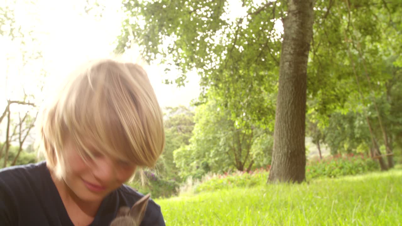 밖에서 토끼를 돌보는 행복한 아이