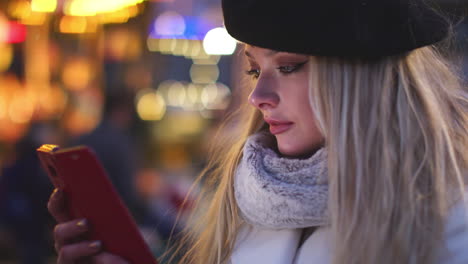 Junge-Frau-Mit-Baskenmütze,-Die-Ihr-Mobiltelefon-überprüft