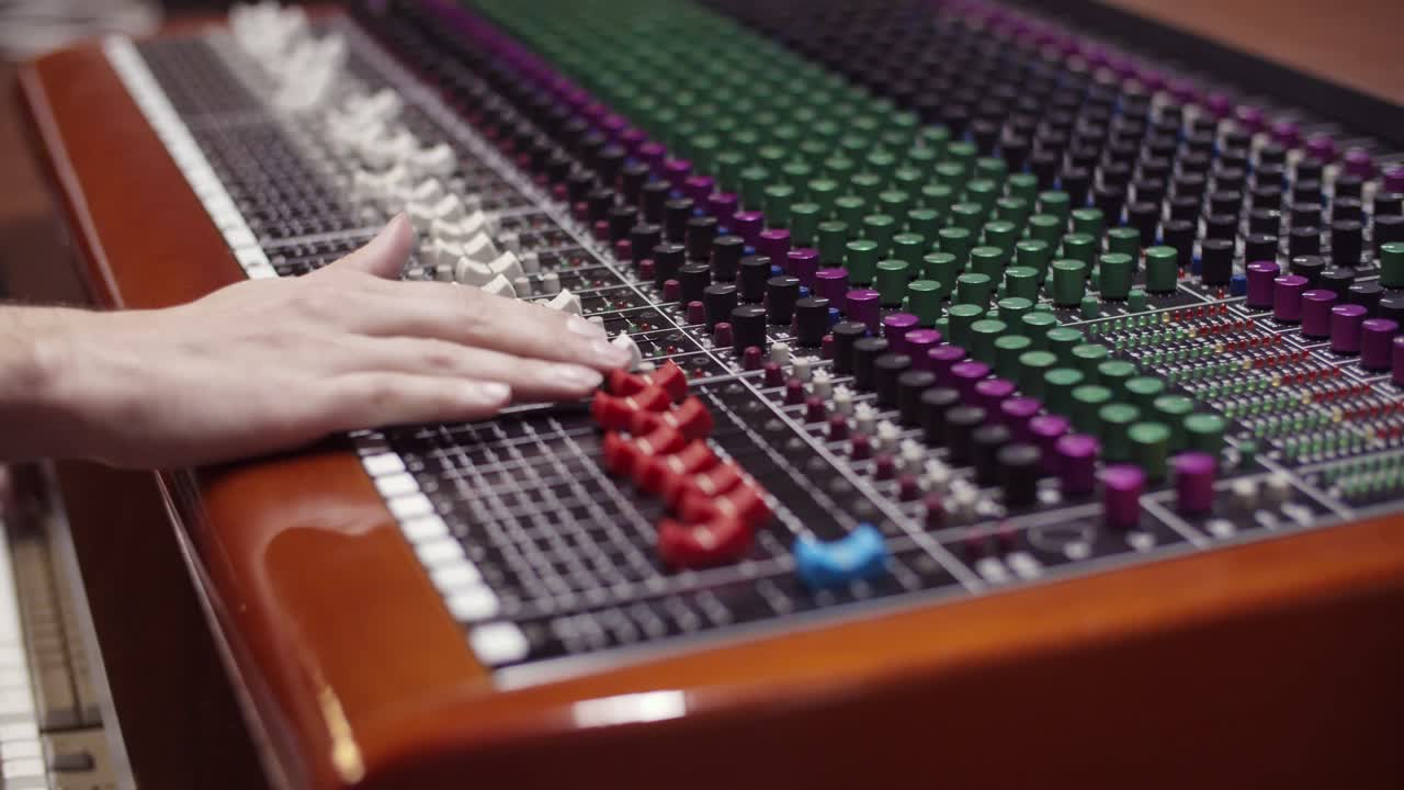 Man in a control room of a recording studio moving a fader with a Toft console - Professional recording studio - 4K at 60fps (slowmotion) - Professional audio vives