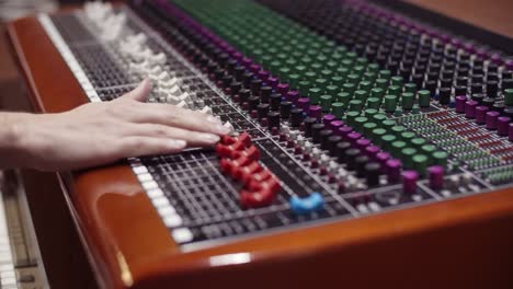 man in a control room of a recording studio moving a fader with a toft console - professional recording studio - 4k at 60fps (slowmotion) - professional audio vives
