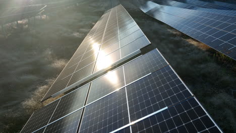 vista aérea hacia atrás sobre una célula fotovoltaica, en un campo solar, frío, tarde de otoño