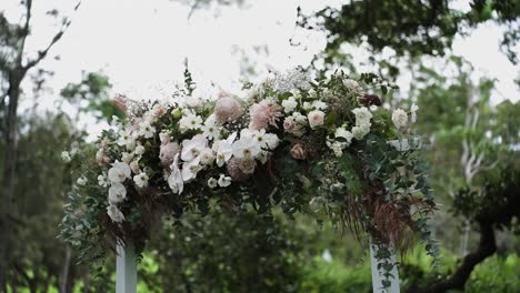 Stylish-Wedding-Arch-Filled-With-Various-Flowers-For-Ceremony-During-Daytime