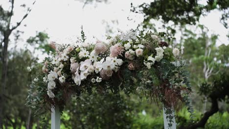 stylish wedding arch filled with various flowers for ceremony during daytime