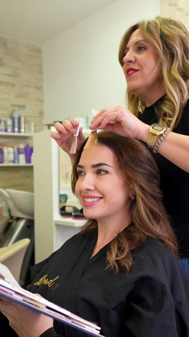 Parrucchiere che aiuta il cliente a scegliere un nuovo colore di capelli in salone