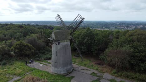 Bidston-hill-disused-rural-flour-mill-restored-traditional-wooden-sail-windmill-Birkenhead-aerial-orbit-left-above-trees-view