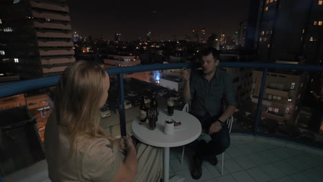 Couple-spending-evening-in-rooftop-cafe-of-night-Tel-Aviv