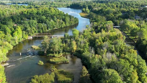 winding rideau river in the summer near ottawa with an old metal bridge and green trees