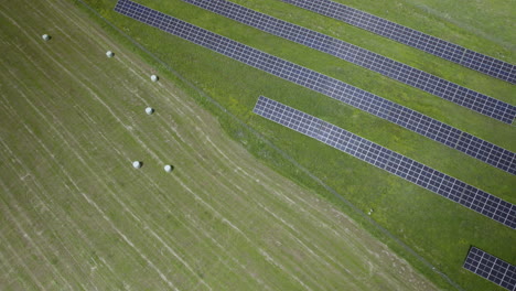 solar pv panels installation array mounted in green field land, new source of energy and electricity technology modules, aerial descending top view