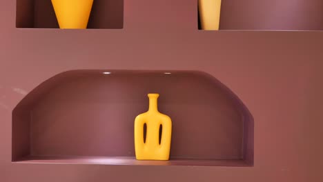 modern yellow vase on a burgundy shelf