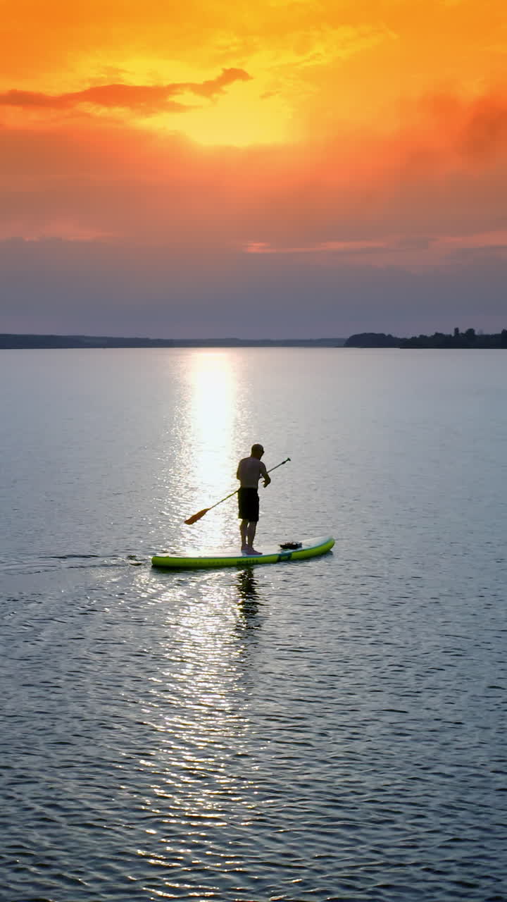 Stand up paddle boarding. Handsome young man standing on sup board