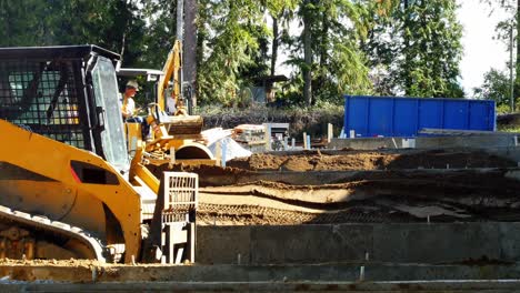 rodillo de carretera y excavadora en el sitio de construcción